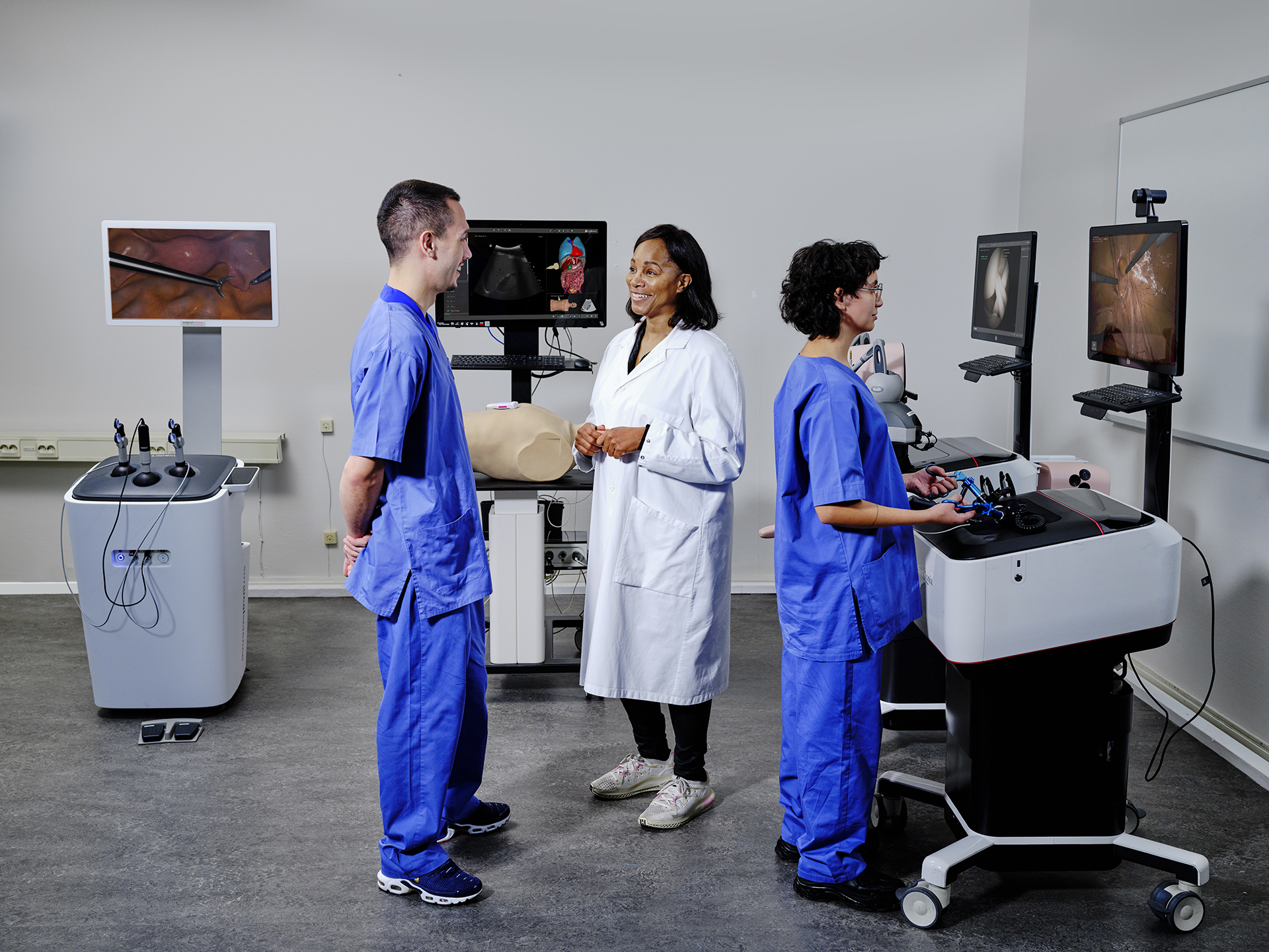 Two doctors talking while another doctor performs a scan