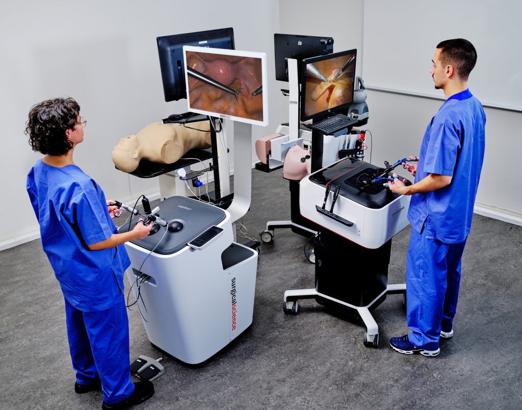 Two doctors performing surgery on dummys using simulators